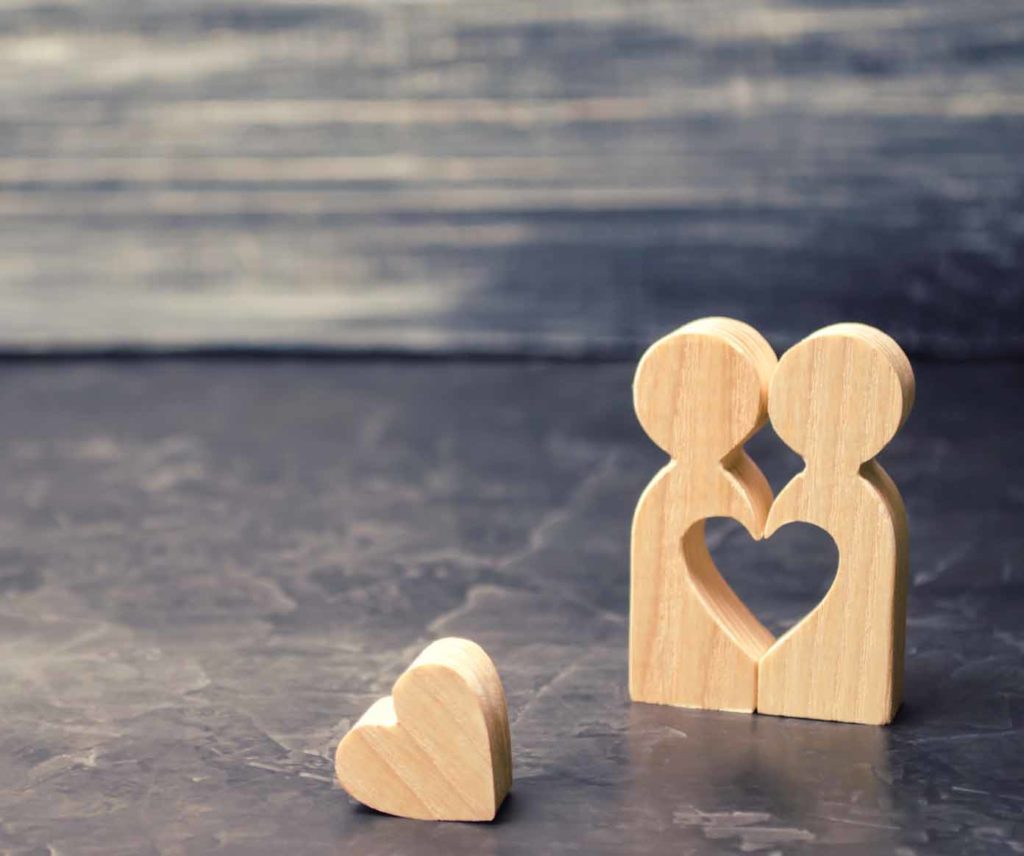 A miniature couple in love and a heart near them. The concept of family problems and loss of feelings for your loved one. Consultation family psychologist. Rupture / divorce. Selective focus